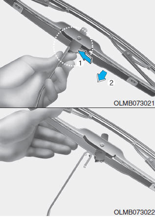 Hyundai Tucson: Wiper blades. 2. Press the clip (1) and slide the blade assembly downward (2).